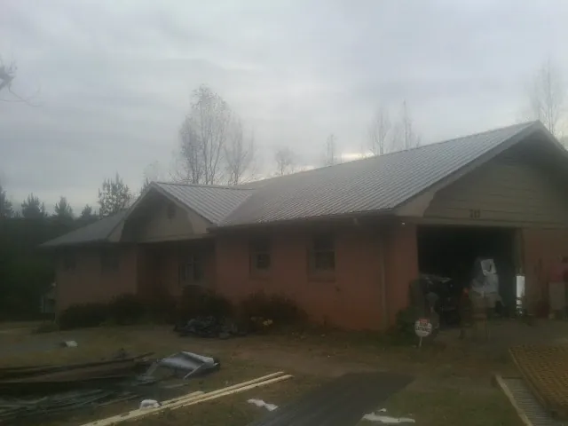 Gray metal roof on a stucco house with an attached garage in Coal City